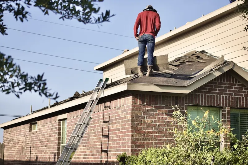 Professional roofer working on a residential roof in West Caldwell